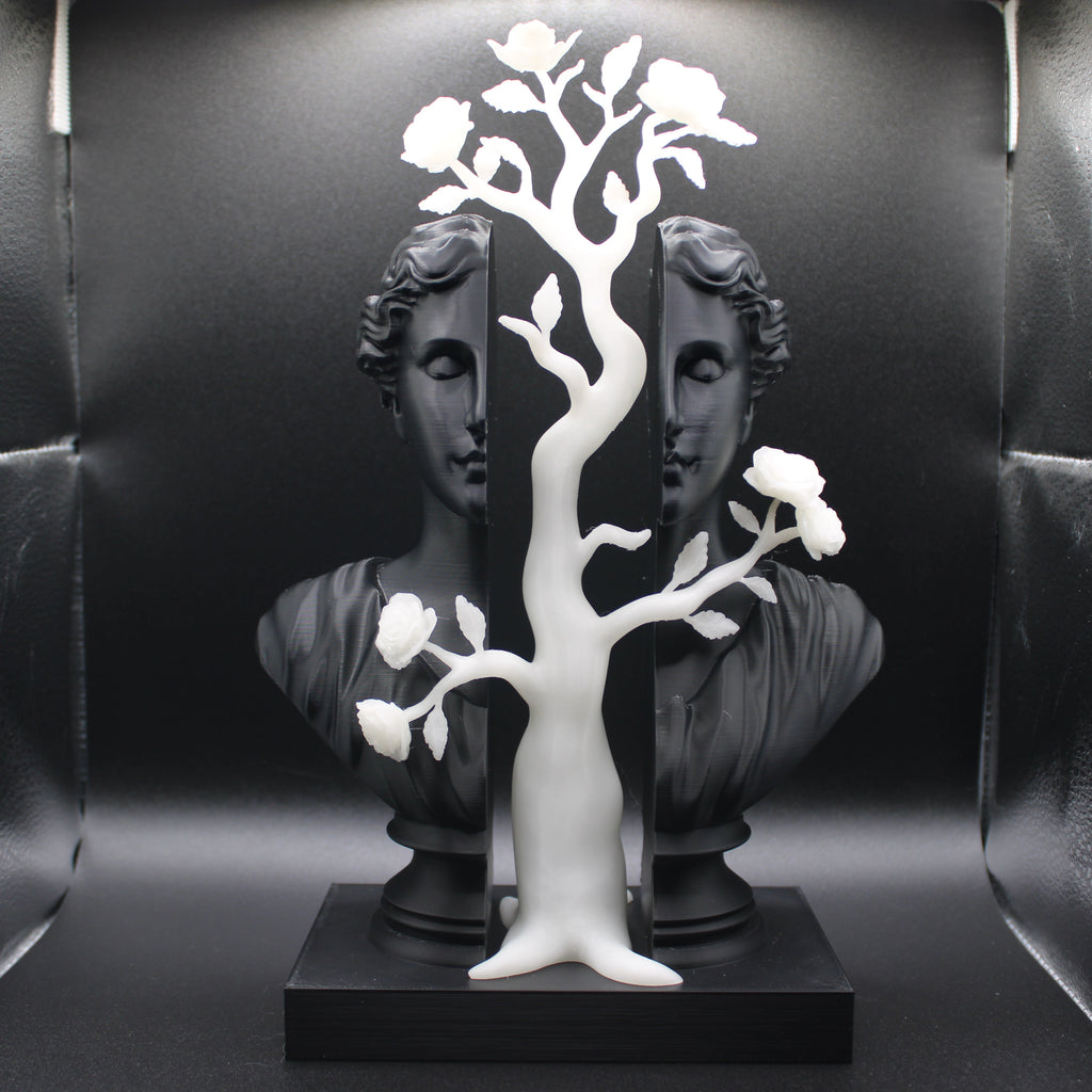 Decorative sculpture with white tree-like structure on a black base against a reflective black background